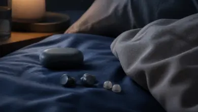 Flache Schlaf-Ohrhörer mit Ladecase und Aufsätzen auf einem Bett